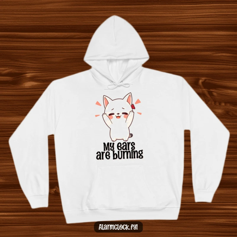Funny hoodie depicting a blushing character covering its ears to escape a loud alarm sound, ideal for conveying a desire for quiet mornings.