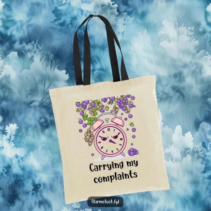 Funny tote bag showing a grumpy alarm clock being pelted by tiny grapes, perfect for carrying items with a humorous, frustrated theme.